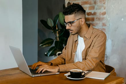 Person writing a blog on a laptop in a calm workspace.